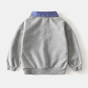 Detail of grey kids sweatshirt with blue checkered faux shirt collar and ribbed cuffs
