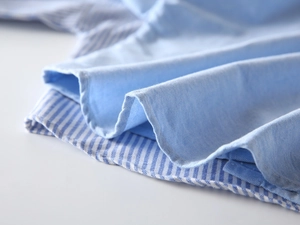 Détail du tissu d'une chemise oxford bleu clair pour garçons avec patchwork à rayures