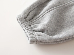 Detailed close-up of grey fleece-lined jogger elastic cuffs with reinforced stitching