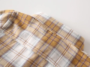 Macro detail of boys brushed flannel shirt collar with classic yellow and brown plaid pattern