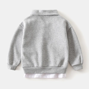 Détail de l'arrière d'un sweat-shirt gris pour garçon avec un ourlet blanc superposé