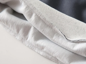 Detail shot of charcoal cotton sweatshirt with grey ribbed hem and stitching