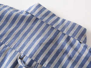 Detailansicht von Kragen und Nähten eines blau gestreiften Baumwollhemdes für Jungen