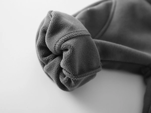 Gros plan sur la doublure polaire épaisse et les coutures du pantalon gris