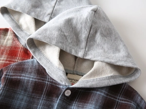 Detailansicht eines Kinder-Kapuzen-Karohemdes mit weichem Flanell und grauer Kapuze