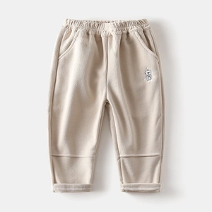 Detail of light beige corduroy pants featuring elastic waist and robot embroidery