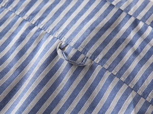 Detailaufnahme von Aufhängerschlaufe und Nähten an blau gestreiftem Jungenhemd