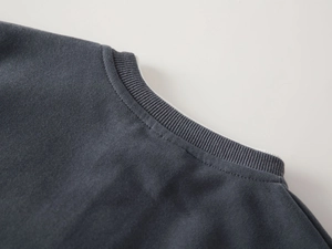 Detail view of ribbed V-neckline and durable double-needle stitching on grey sweatshirt
