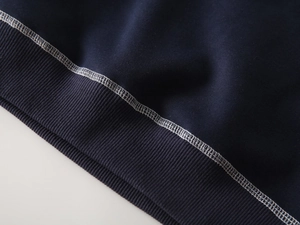 Detail of navy boy sweatshirt showing white contrast stitching and ribbed knit cuffs
