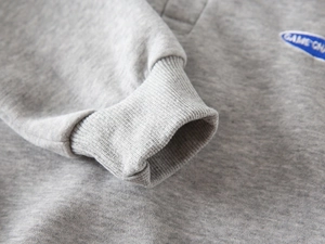Detailed macro view of the grey ribbed cuffs and Game On embroidery on the sleeve