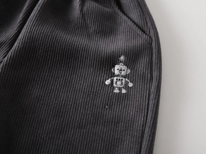 Detailed view of robot embroidery on dark grey corduroy winter pants for boys