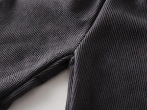 Detail of multi-needle stitching on dark grey corduroy pants for children's winter wear