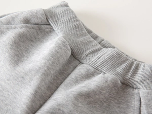 Close-up of gray knit children's pants showing elastic waistband and fabric texture