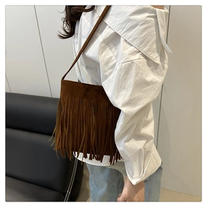 Détail d'un sac seau en daim marron avec de longues franges et une fine bandoulière
