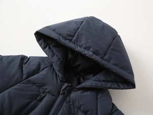 Detailed view of kids navy blue puffer jacket with functional zippers and hood
