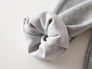 Vue macro du tissu tricoté gris montrant des coutures de qualité et une texture douce