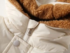 Detail of cream kids hooded vest showing brown sherpa lining and resin zipper closure