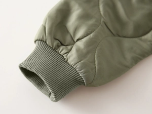Detail of army green quilted sleeve with matching elastic ribbed knit cuff for boys
