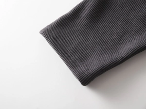 Detail view of thickened dark grey ribbed knit cuffs on warm winter children pants