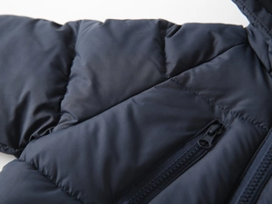Close-up of navy blue quilted puffer jacket with durable fabric and zipper detail