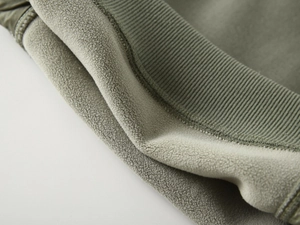 Detail of warm olive green sweatshirt showing soft fleece lining and ribbed knit cuff