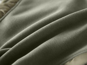 Close-up of heavy knit fabric in olive green showing soft texture and premium cotton fibers