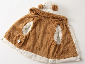 Close-up of thick fleece lining and bear ear hood on kids winter puffer vest
