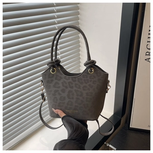 Detail of grey leopard print bucket bag with gold hardware and dual ring handles