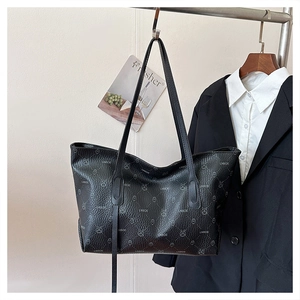 Dettaglio ravvicinato della borsa tote in pelle nera con motivi monogramma di coniglio