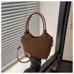 Detailed macro of brown leopard print tote bag with gold lettering and adjustable strap