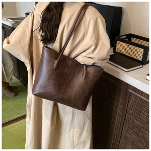Detailed view of dark brown vintage leather tote bag showing fashion tag and textures