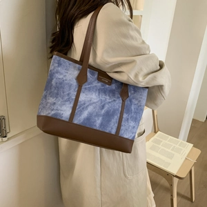 Stylish blue tie-dye tote bag with brown leather accents for women commuting daily