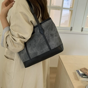 Chic grey canvas tote bag with black leather straps for versatile daily commuting