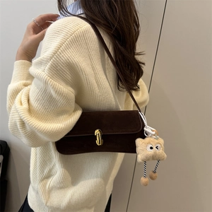 Sac sous le bras en daim marron avec fermoir doré et charme peluche sur modèle
