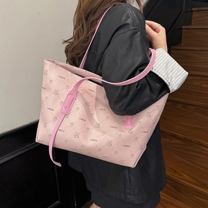 Borsa tote rosa con motivo a griglia e stampa a coniglietto indossata a spalla da modella