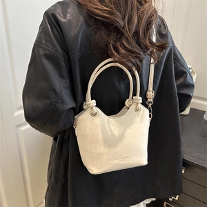 Chic off-white large capacity bucket bag worn with a black leather jacket for women