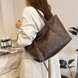 Borsa tote in pelle marrone scuro con monogramma a forma di coniglio e tracolla indossata da modella