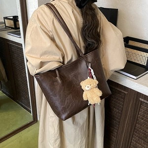 Retro dark brown tote bag with FASHION embossed logo, plush bear, and silk scarf