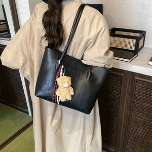 Retro black oversized tote bag in crackle leather with a cute plush bear charm