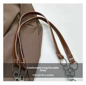 Close-up of brown leather strap with white stitching and polished silver metal rings