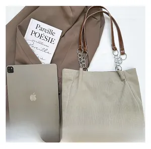 Detailed comparison of the large corduroy tote bag size relative to an iPad Pro tablet