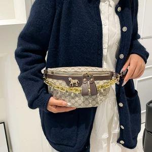 Fashionable monogram saddle bag with golden horse emblem and chain strap worn by model