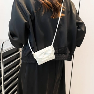 Schicke weiße Mini-Umhängetasche mit großer Schleife und Spitze, am Model präsentiert