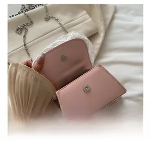 Dettaglio della borsa rosa con bordo in pizzo bianco e chiusura magnetica in metallo