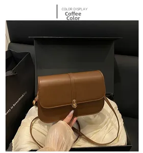 Detail of coffee brown PU leather bag with gold buckle in a luxury gift box