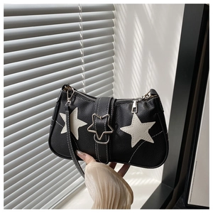 Detail of black pebbled leather handbag featuring white star patches and star metal buckle