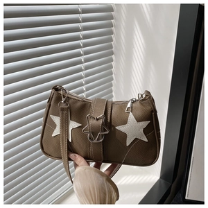 Detail shot of brown lychee-textured leather bag with white star patches and metal buckle