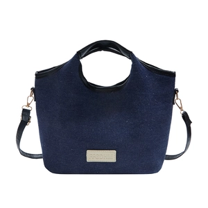 Deep blue denim bucket bag with black top handle and adjustable leather strap