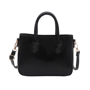 Vintage black crossbody bag with round handles and gold hardware in front view