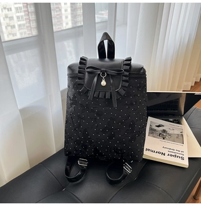 Vue détaillée du sac à dos noir à pois avec décoration nœud et pendentif perle